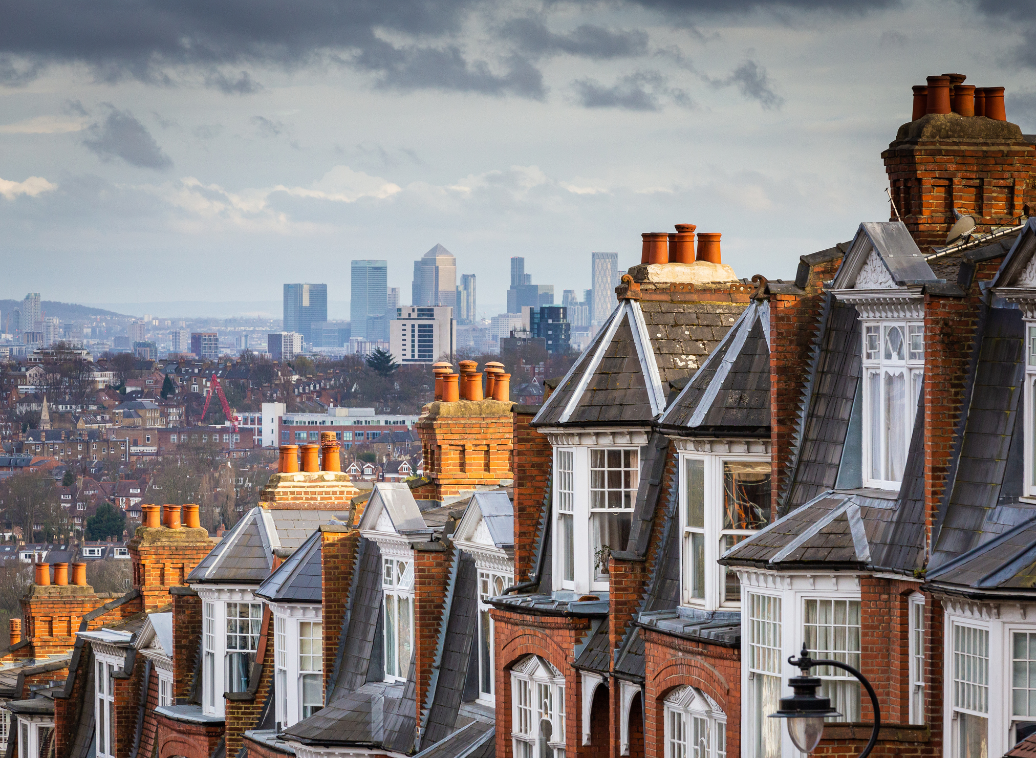Victorian red-brick London terraces with dormer windows and chimney pots in the foreground.